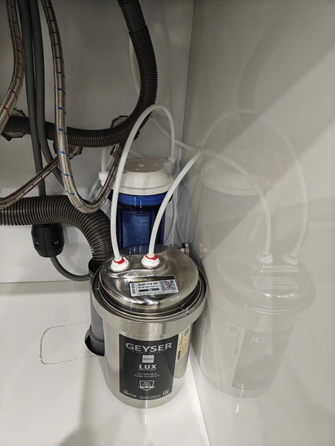 Geyser Ecotar Lux lắp đặt thực tế trong góc tủ bếp, hai đường ống nước nối vào đầu máy